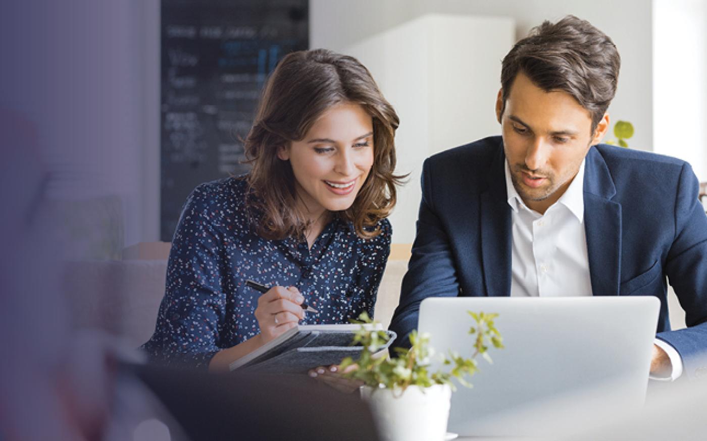 Man and woman staring at a computer.