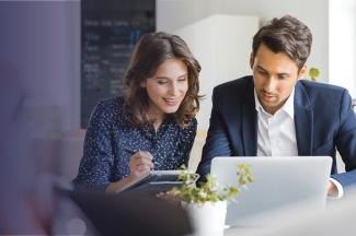 Man and woman staring at a computer.